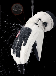 Close-up of waterproof winter ski gloves showing water droplets on the fabric surface