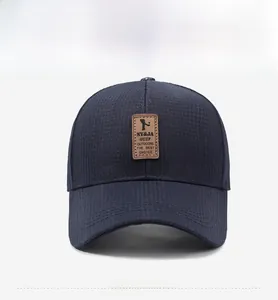 Front view detail of navy corduroy baseball cap featuring a premium brown leather patch