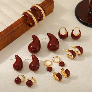 Detail of red enamel earrings set in water drop, heart and C-shapes with gold plating