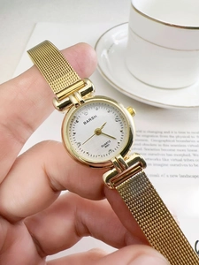 Close-up of vintage gold quartz watch with a metal mesh band and elegant gold dial