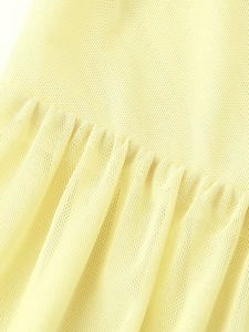 Close-up of pale yellow knit fabric showing texture and soft pleat craftsmanship