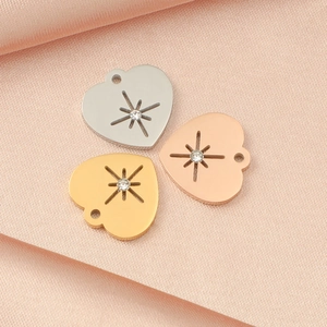 Detailansicht der herzförmigen Anhänger in Silber, Gold und Roségold auf Seide