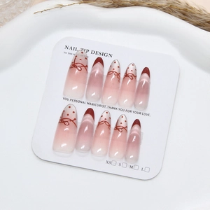 Pink and burgundy gradient cat eye press-on nails with bow and polka dot nail art design