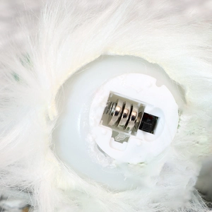 Detail of the white plush Christmas gnome base showing battery compartment and power switch