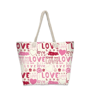 Close-up of canvas tote bag with pink LOVE print, hearts, and cream rope handles