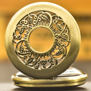 Macro shot of vintage bronze pocket watch featuring intricate hollow-out floral carvings