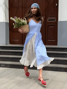 Blue gingham slip dress with layered white ruffle hem in a stylish outdoor street view