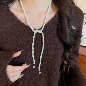 Detailed view of Y-shaped pearl necklace with sparkling teardrop crystal pendant