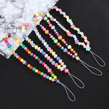 Detail of five colorful beaded phone lanyards with stars and flowers on marble background