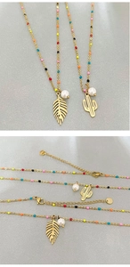 Detail of gold chain necklaces with colorful enamel beads and leaf cactus charms