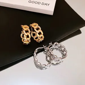 Interlocking Cuban link earrings in gold with pavé cubic zirconia and polished silver finish