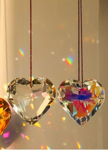 Close-up of heart-shaped crystal pendants with multi-faceted cut and light refraction