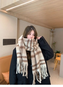 Close-up of soft beige and brown plaid mohair scarf with elegant tassel details