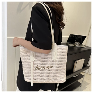 Detail of woven tote bag with Suemmr embroidery and white shoulder straps in beige color