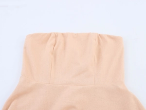 Primo piano dell'abito lungo beige senza spalline con dettagli etnici e frange