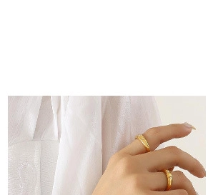 Close-up of elegant gold plated rings with white seashell inlay on female hand