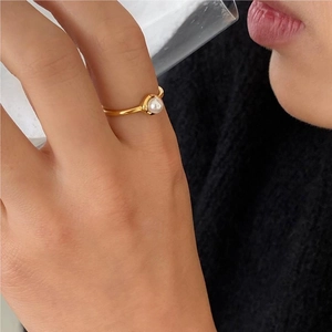 Minimalist gold pearl ring shown on model hand with elegant lifestyle aesthetic