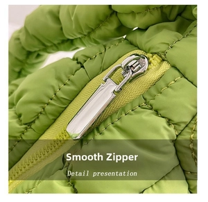 Nahaufnahme eines hochwertigen Metallreißverschlusses an einer grünen gesteppten Tasche