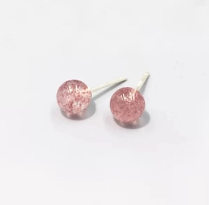 Macro shot of minimalist S999 sterling silver stud earrings with pink strawberry quartz
