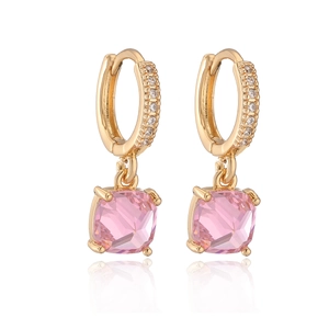 Orecchini dorati con cristallo rosa quadrato e zirconi su sfondo bianco riflettente