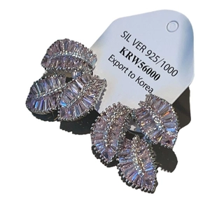 Elegant silver leaf drop earrings with sparkling purple zircon inlays on display card