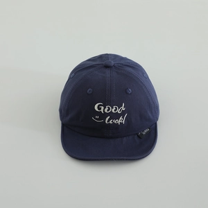 Close-up of navy blue soft-brim baby baseball cap with Good Luck embroidery and smiley face