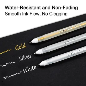 Metallic gold silver and white paint pens for drawing on black paper surface