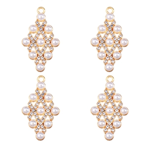 Detailed view of four golden rhombus pendants with inlaid pearls and sparkling crystals