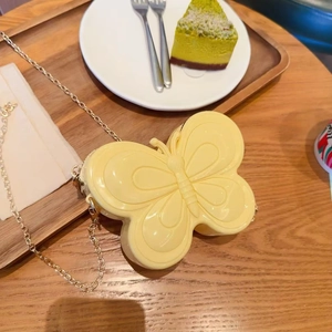 Détail d'un sac à chaîne papillon jaune en gelée sur une table en bois avec dessert