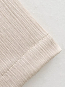Détail du tricot côtelé beige clair montrant les coutures fines et la texture premium