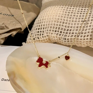 Detail of gold plated necklace featuring a red enamel pony and heart pendant with zircon