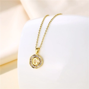 Macro shot of 18K gold plated necklace featuring a round letter G pendant with zircon