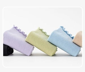 Detail of five pairs of ribbed yoga socks with ruffled cuffs in various pastel colors