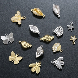 Macro shot of gold and silver bee butterfly starfish charms with sparkling crystals