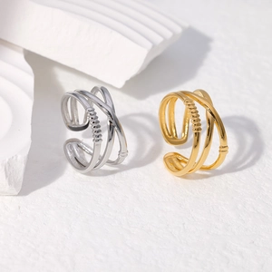 Detail view of triple-layered open rings in gold and silver with textured engraving