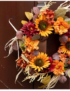 Close-up of 45cm artificial sunflower wreath with autumn berries on dark wood background