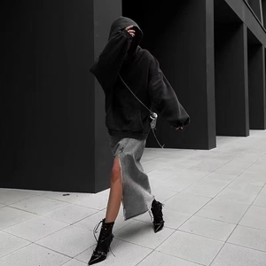 Detail of black rhinestone hoodie paired with a grey split denim skirt and black boots