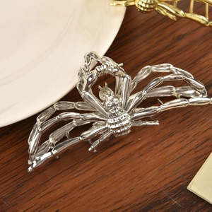 Detail shot of a silver alloy spider hair claw clip with metallic finish on wood background