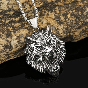 Detailed engraving of a Viking wolf head pendant on rugged stone and reflective surface