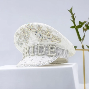 Close-up of white sequin captain hat with BRIDE pearls and rhinestone crown detail