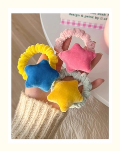Detailed view of yellow, blue and pink plush star hair ties with elastic bands