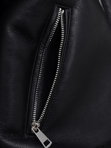 Detailed macro view of the silver metal zipper and premium black leather texture on the jacket