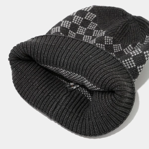 Detail of grey diamond knit beanie featuring thick texture and ribbed cuff design