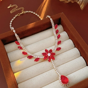 Detail of flower and teardrop necklace with red stones and zircon in a jewelry box