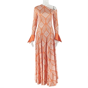 Detail of orange geometric pattern dress with asymmetric shoulder and flared long sleeve
