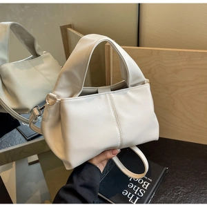 Close-up of white lychee pattern leather bag with detachable strap and gold hardware