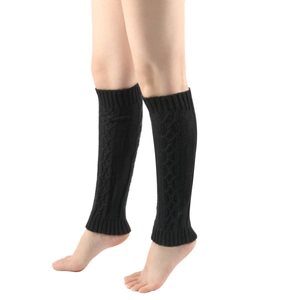 Detail of black cable knit leg warmers showing ribbed cuffs and thick wool texture