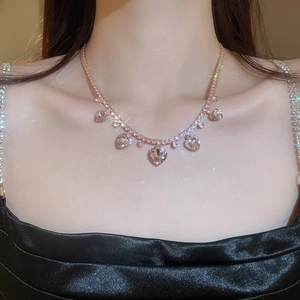 Elegantly sparkling rose gold heart necklace with zircon tassels worn on a model's neck