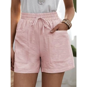 Detail of pink linen-style shorts featuring elastic drawstring waist and large side pockets
