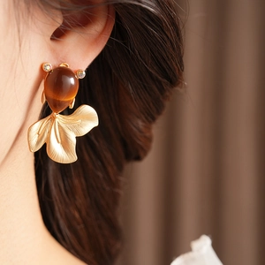 Macro view of vintage goldfish earrings with amber stones and gold metal details